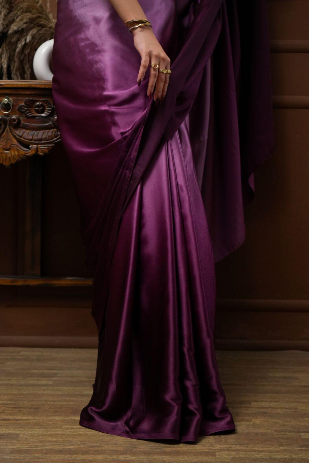 A woman models Viola Burgundy Glass Shine Satin Saree