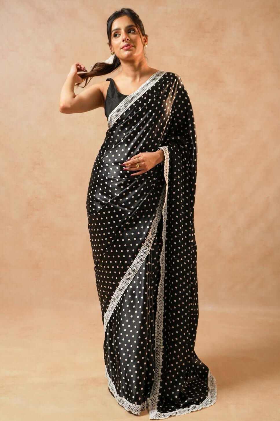 Daisy Dot Black Satin Polka Dot Saree with Crochet Border model wearing saree, showcasing black satin fabric and polka dots.