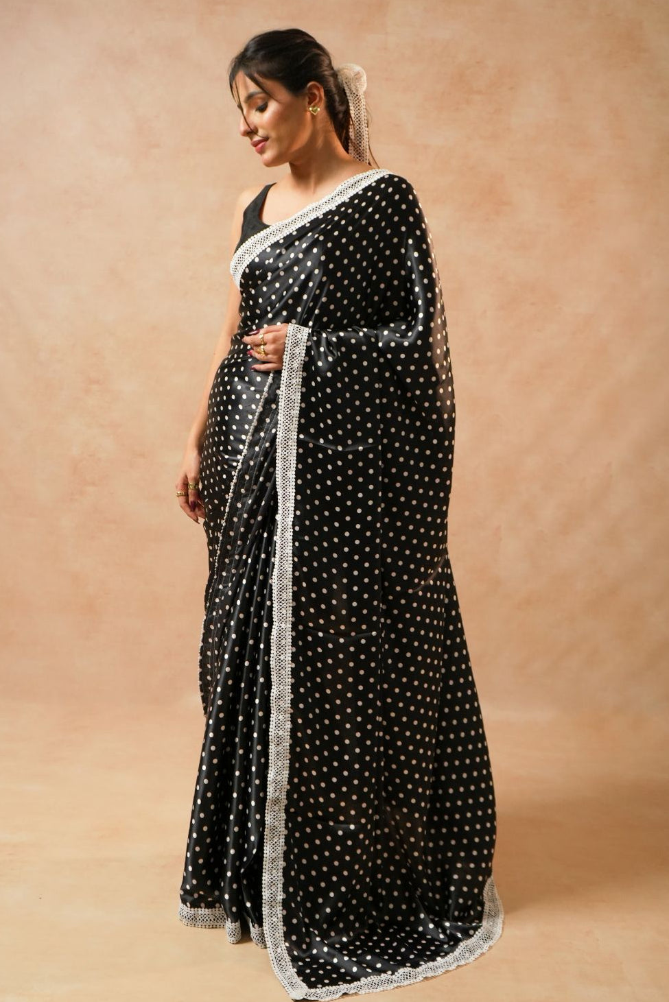 Daisy Dot Black Satin Polka Dot Saree with Crochet Border worn by a model, showcasing the elegant design and length.