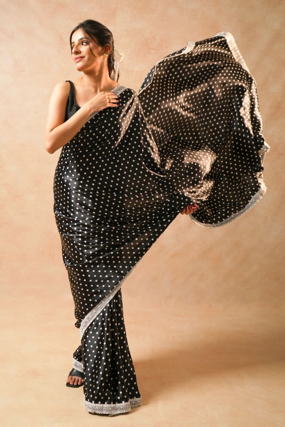 Daisy Dot Black Satin Polka Dot Saree with Crochet Border showcased by model, highlighting polka dots and crochet border details.