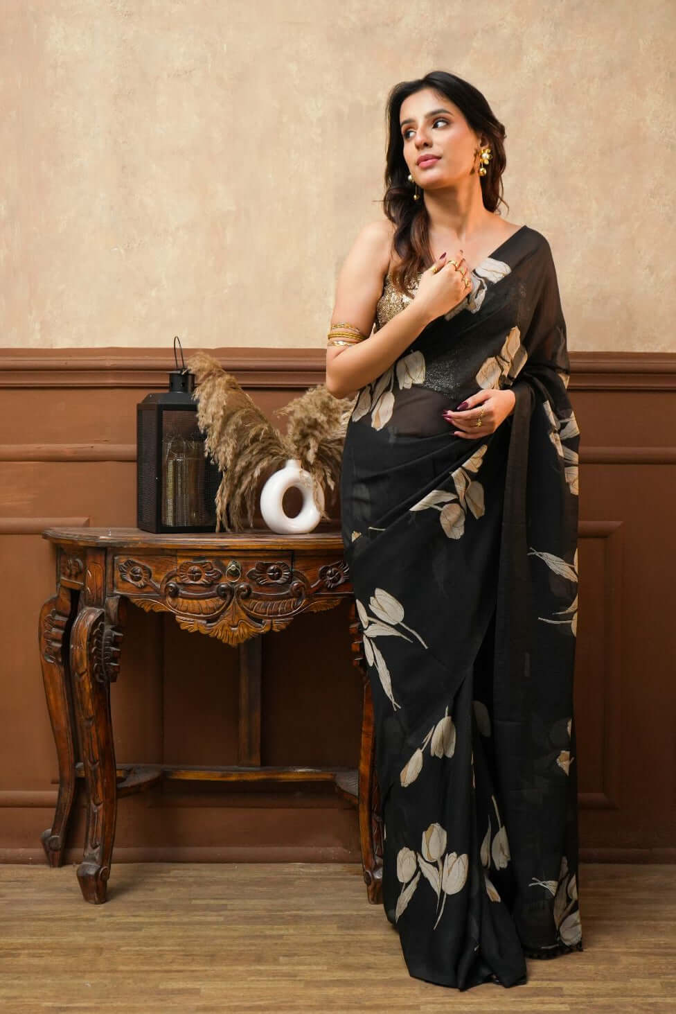 A woman wearing a Dusk Petals Black Pure Georgette Saree with Tulip Print