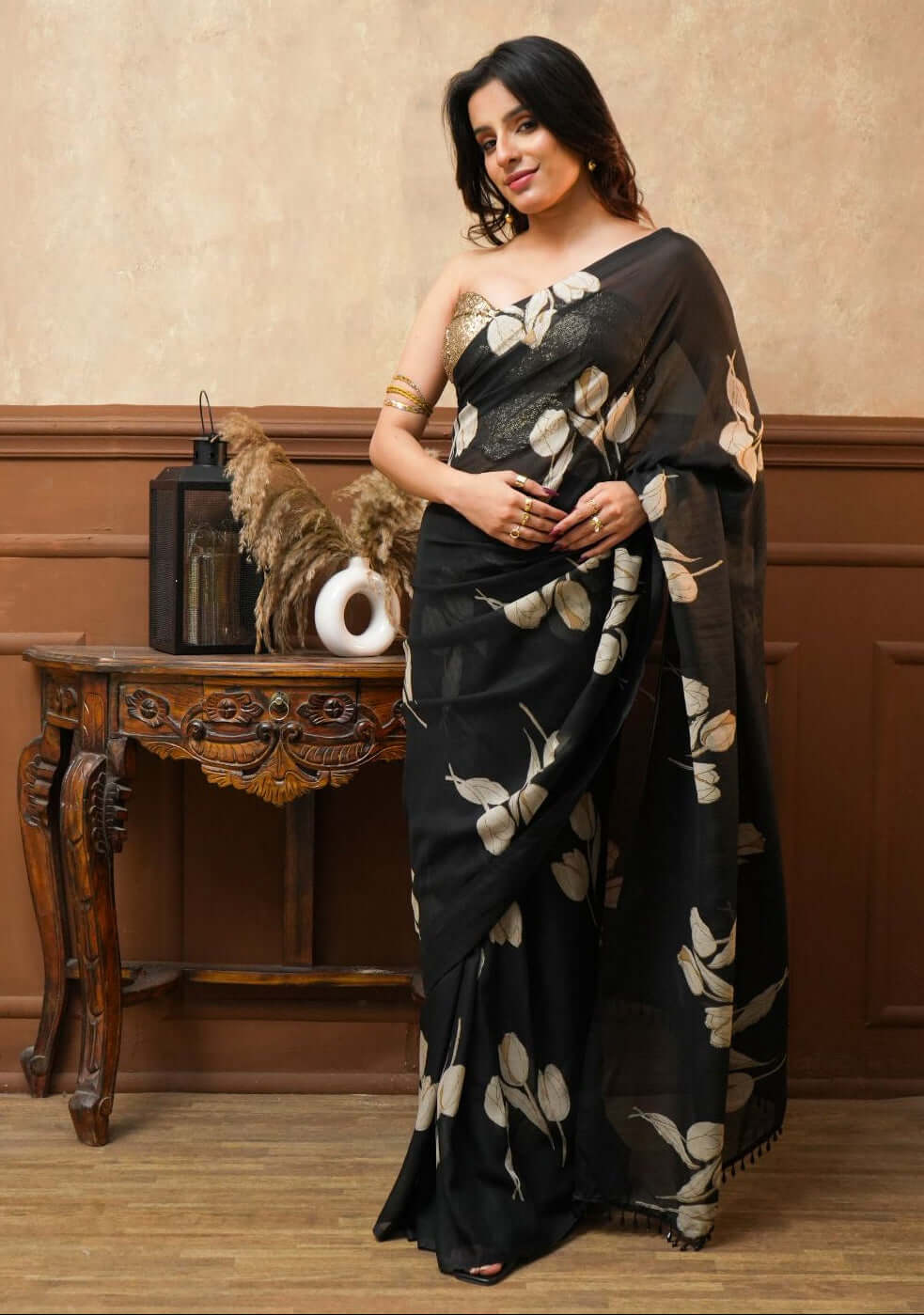 A woman wearing a Dusk Petals Black Pure Georgette Saree with Tulip Print