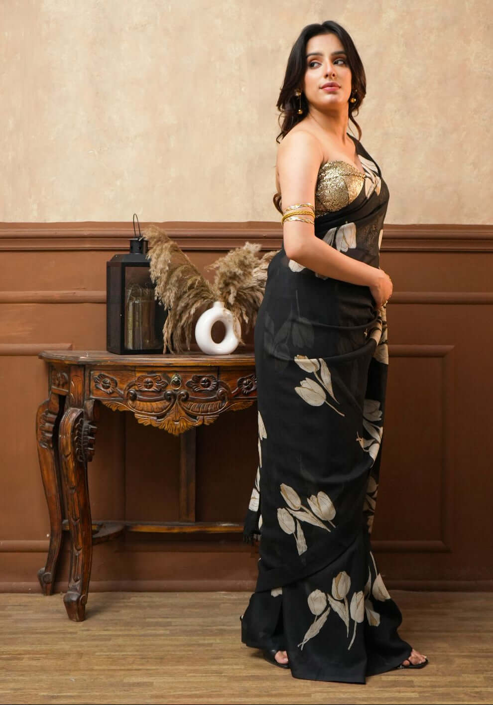 A woman wearing a Dusk Petals Black Pure Georgette Saree with Tulip Print