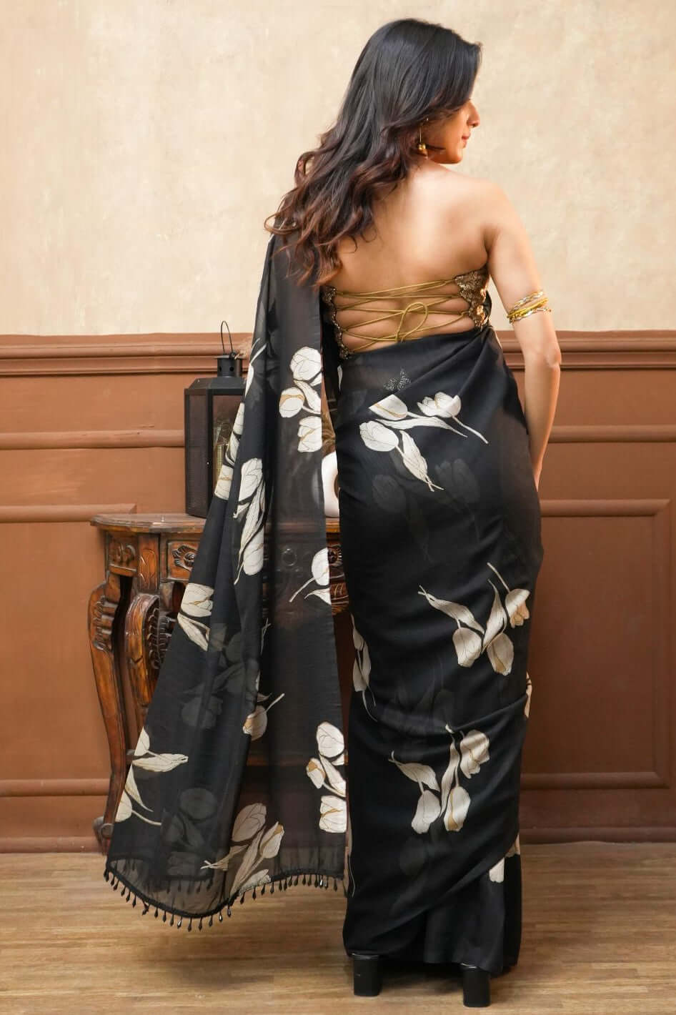  A woman wearing a Dusk Petals Black Pure Georgette Saree with Tulip Print A woman wearing a Dusk Petals Black Pure Georgette Saree with Tulip Print