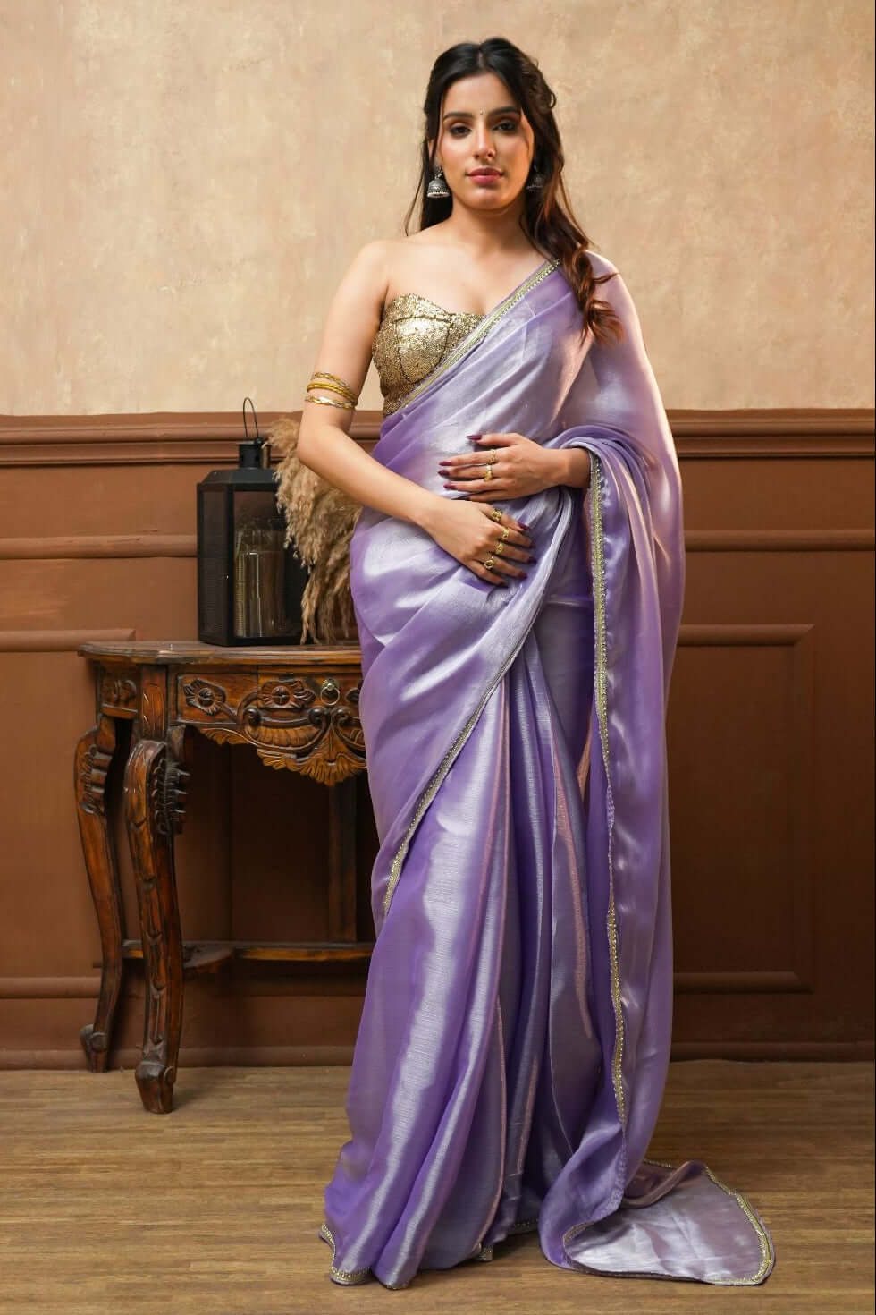 A woman wearing a Noor Lavender Tissue Silk Saree with Gold Border 