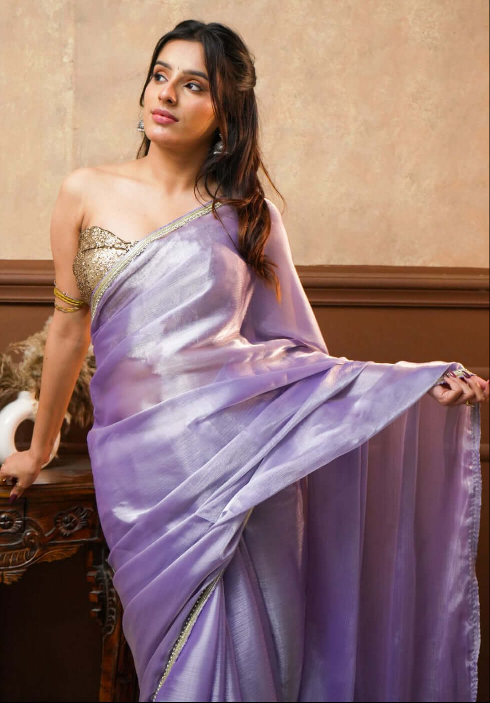 A woman wearing a Noor Lavender Tissue Silk Saree with Gold Border 
