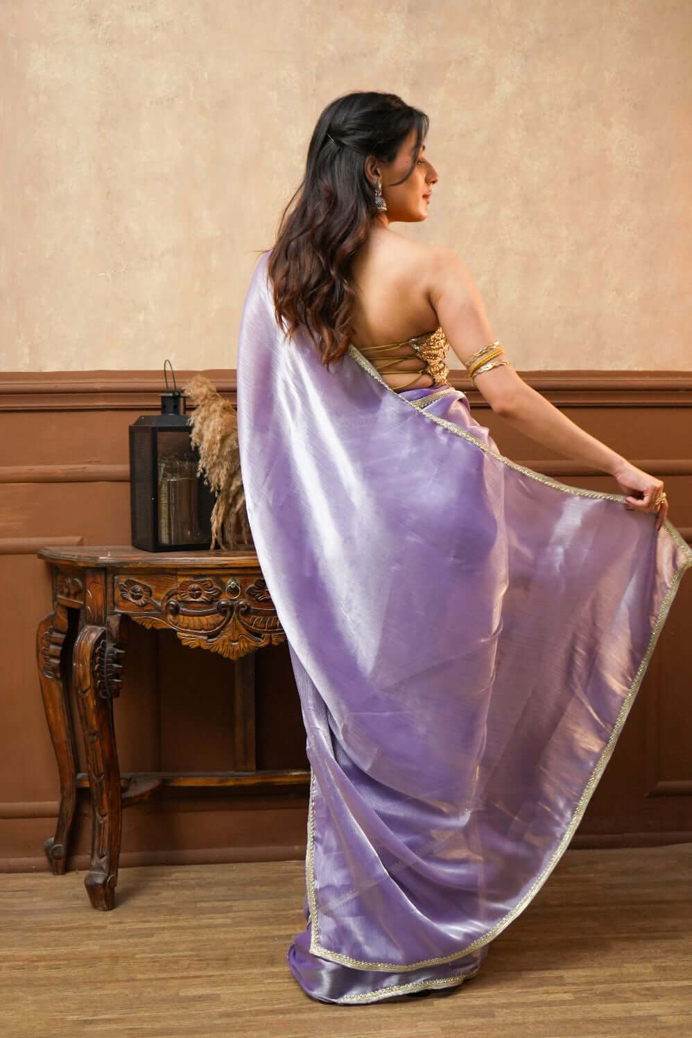 A woman wearing a Noor Lavender Tissue Silk Saree with Gold Border 
