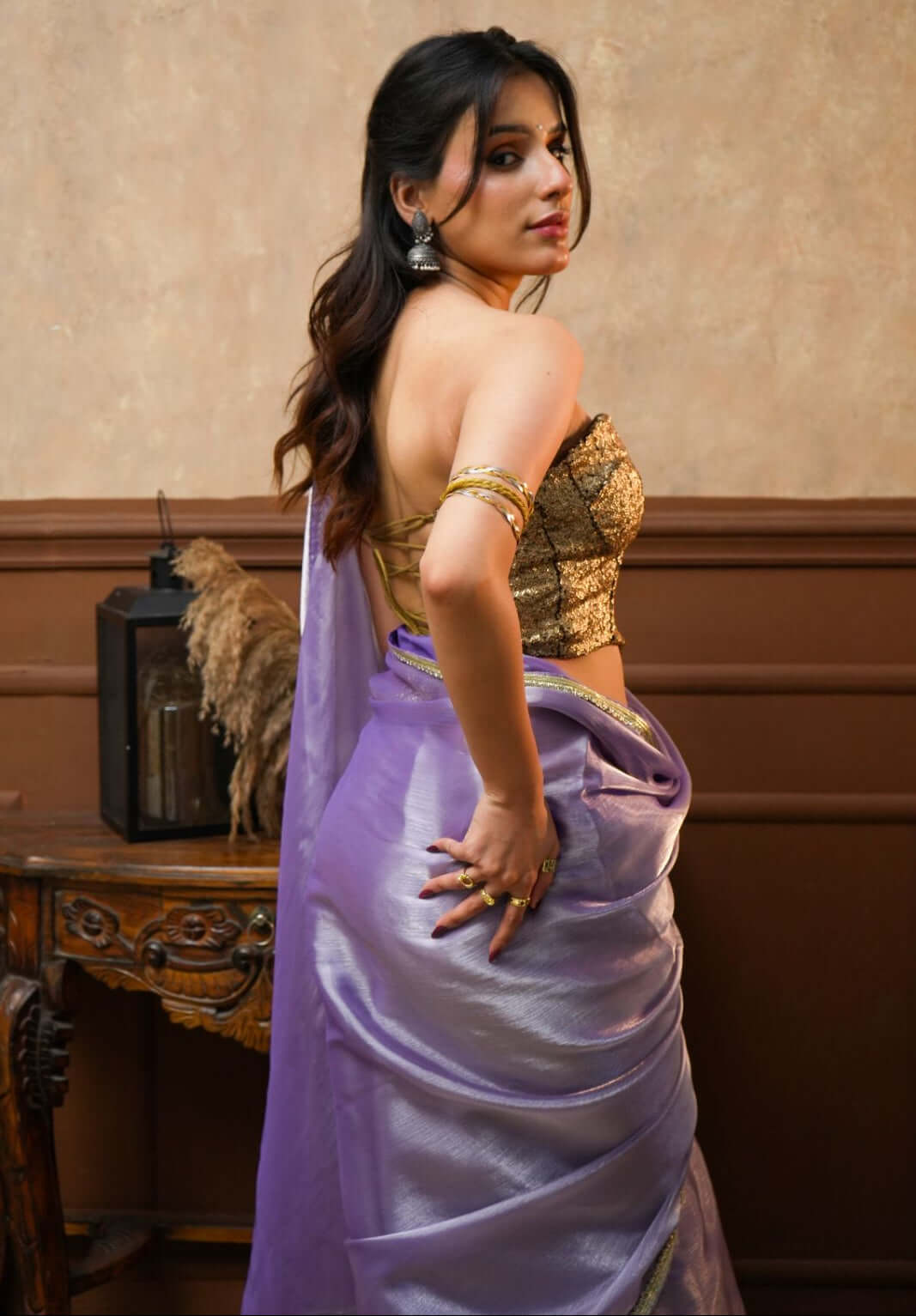 A woman wearing a Noor Lavender Tissue Silk Saree with Gold Border 