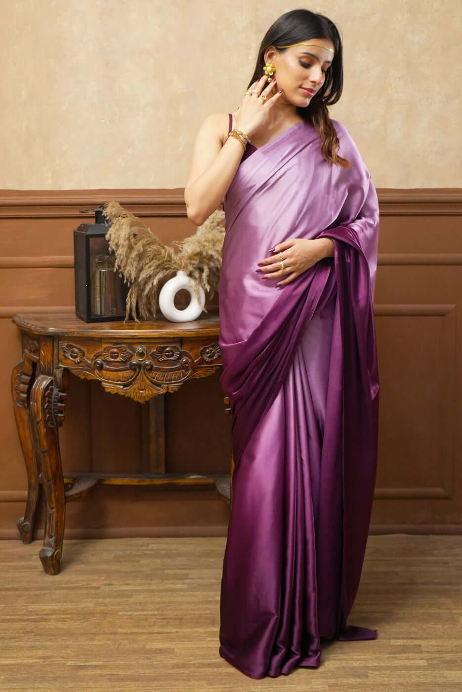 A woman models Viola Burgundy Glass Shine Satin Saree