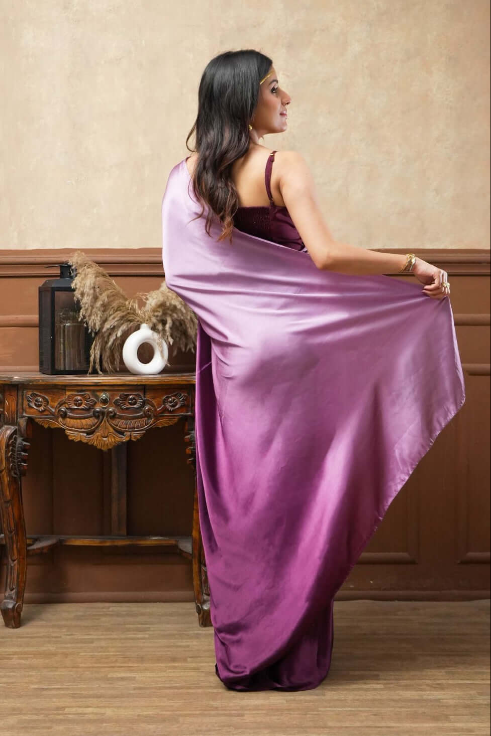A woman models Viola Burgundy Glass Shine Satin Saree
